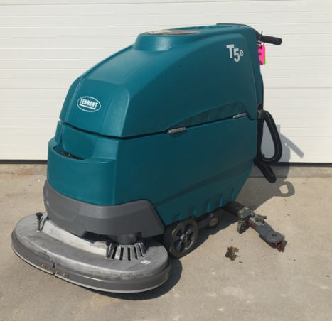 Tennant T5e industrial floor scrubber machine parked on concrete floor.